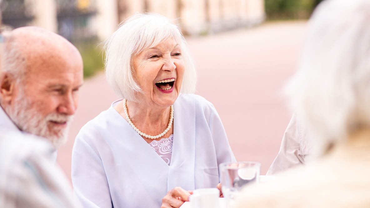 Älteres Paar lacht mit Gegenüber