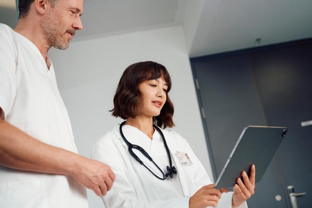 Ärztin und Arzt schauen auf ein Tablet